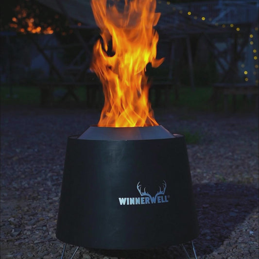 brandende smokeless fire pit met hoge vlammen uit de bovenkant, geplaatst op een grindondergrond met zichtbaar Winnerwell-logo aan de voorkant