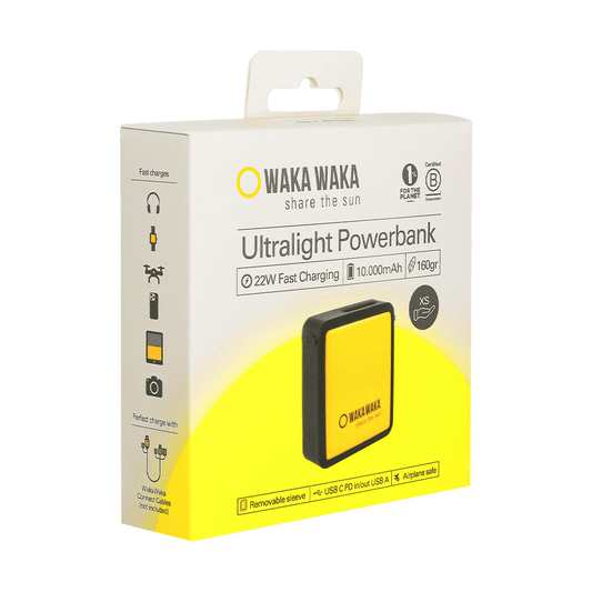 Een productverpakking van een WakaWaka Ultralight Powerbank met een afbeelding van de geel-zwarte powerbank op de voorkant; op de doos staat “WAKA WAKA – share the sun”, “Ultralight Powerbank” en specificaties zoals 22W fast charging, 10.000 mAh en 160 gram, met pictogrammen voor gebruik met verschillende apparaten.
