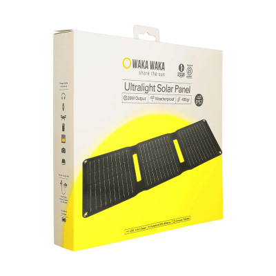 Een productverpakking van een WakaWaka Ultralight Solar Panel met een afbeelding van een opvouwbaar zonnepaneel op de voorkant; op de doos staat “WAKA WAKA – share the sun”, “Ultralight Solar Panel” en specificaties zoals 20W output, waterproof, 400 gram en IP65, met pictogrammen voor gebruik met verschillende apparaten.
