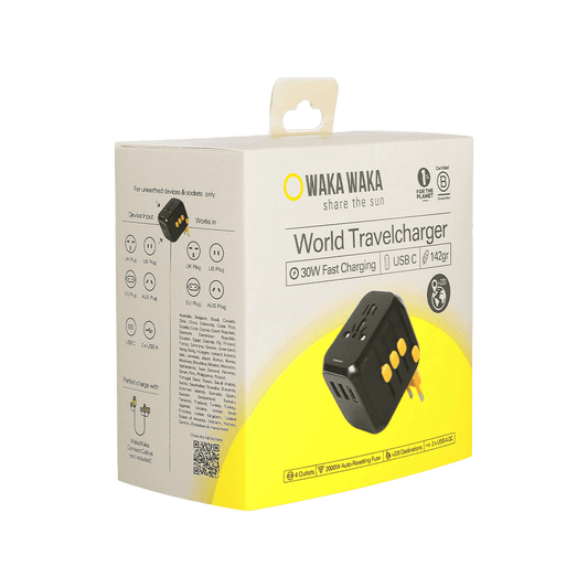 Een productverpakking van een WakaWaka World Travelcharger met een afbeelding van de zwarte reisstekker met gele accenten; op de doos staat “WAKA WAKA – share the sun”, “World Travelcharger” en specificaties zoals 30W fast charging, USB-C en 142 gram, met pictogrammen voor wereldwijde stekkertypes en gebruik.
